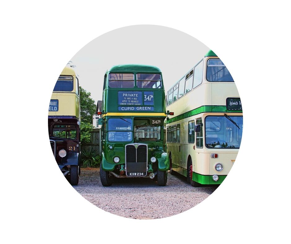 three old style buses green and cream