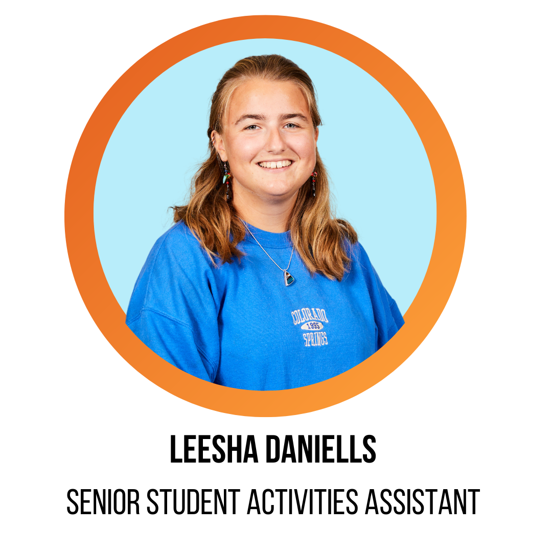 leesha daniells, senior student activities assistant, smiling in front of a blue background