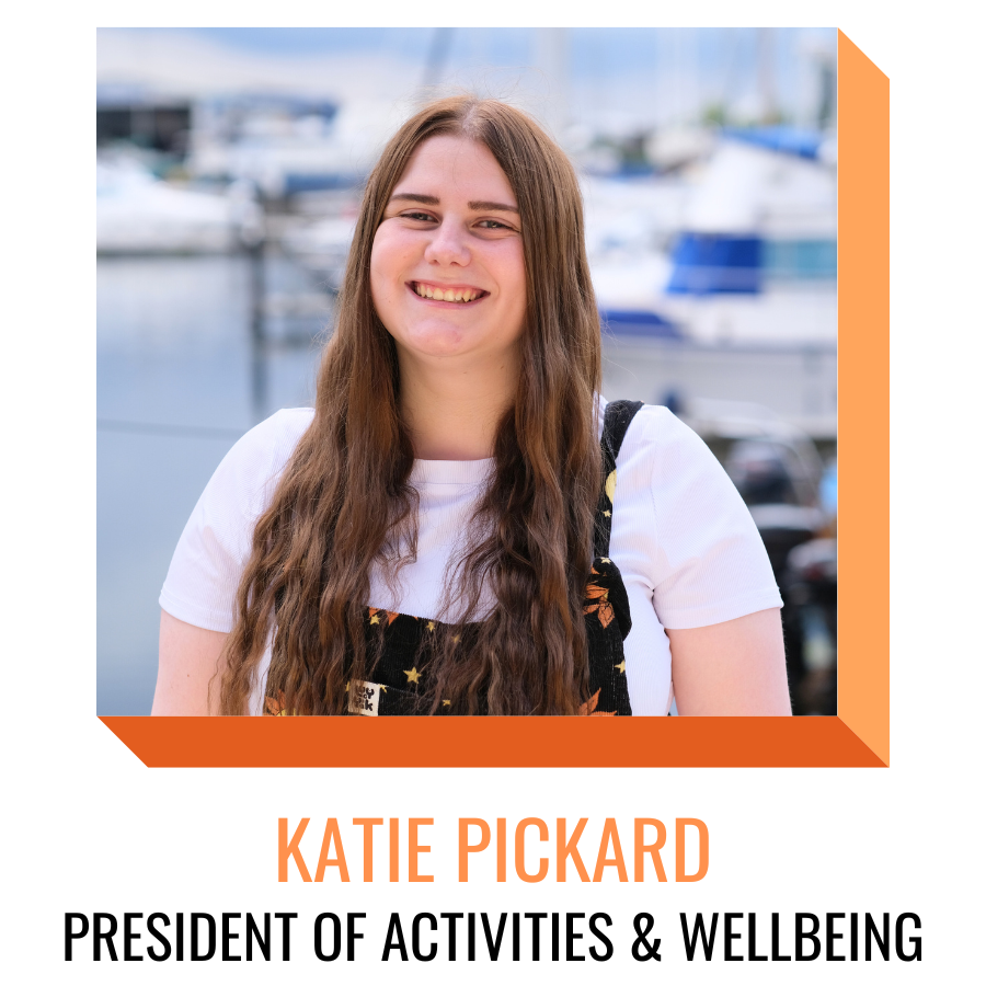 Katie pickard, president of activities and wellbeing, smiling in front of the marina